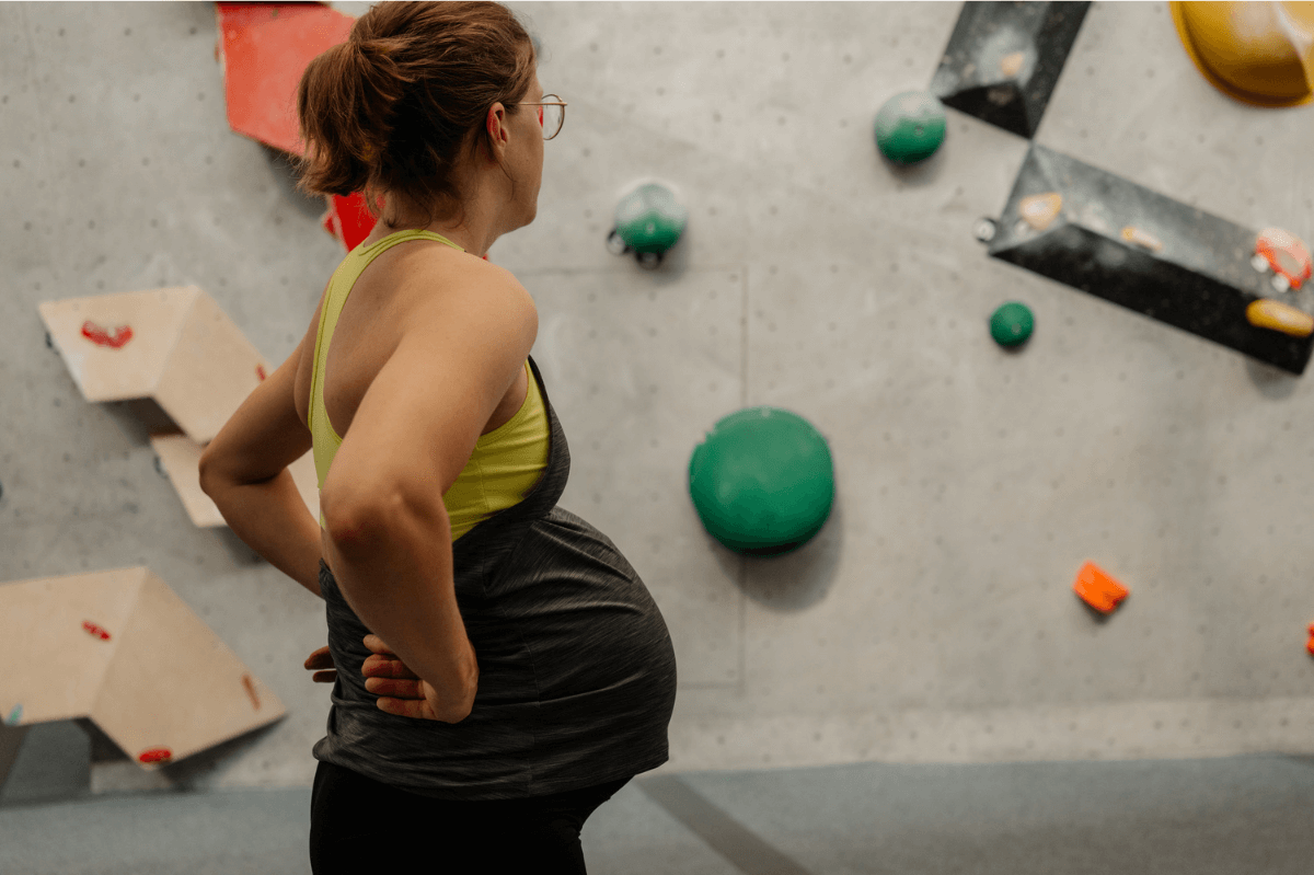 schwangere Kletterin in der Boulderhalle, schwanger Bouldern